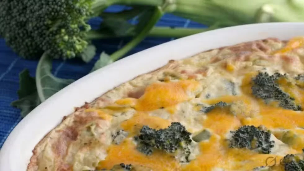 Low-carb turkey and broccoli casserole with melted cheddar cheese in a baking dish